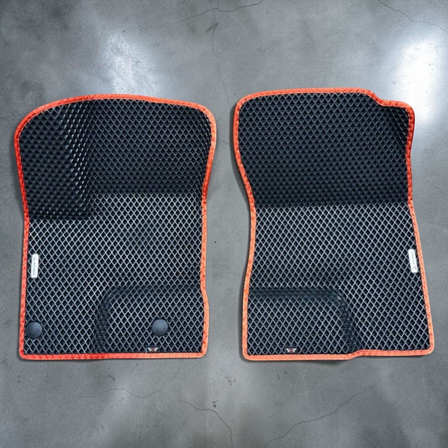 Custom front EVA floor mats for Mitsubishi Outlander PHEV 2022–2025, black EVA material with orange trim. Designed for driver and passenger side with raised edges for superior protection from water, snow, and dirt.