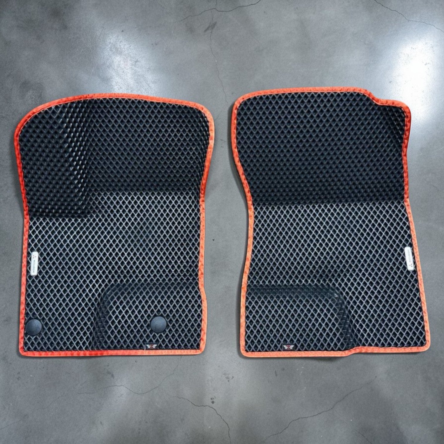 Custom front EVA floor mats for Mitsubishi Outlander PHEV 2022–2025, black EVA material with orange trim. Designed for driver and passenger side with raised edges for superior protection from water, snow, and dirt.